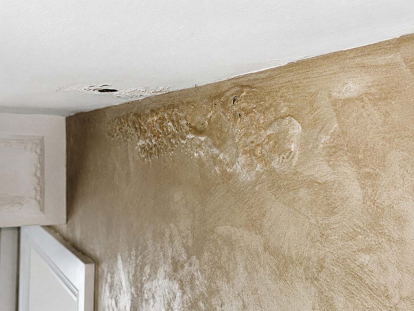 Water damage visible on the wall and ceiling below a leaking shower tray in Ongar