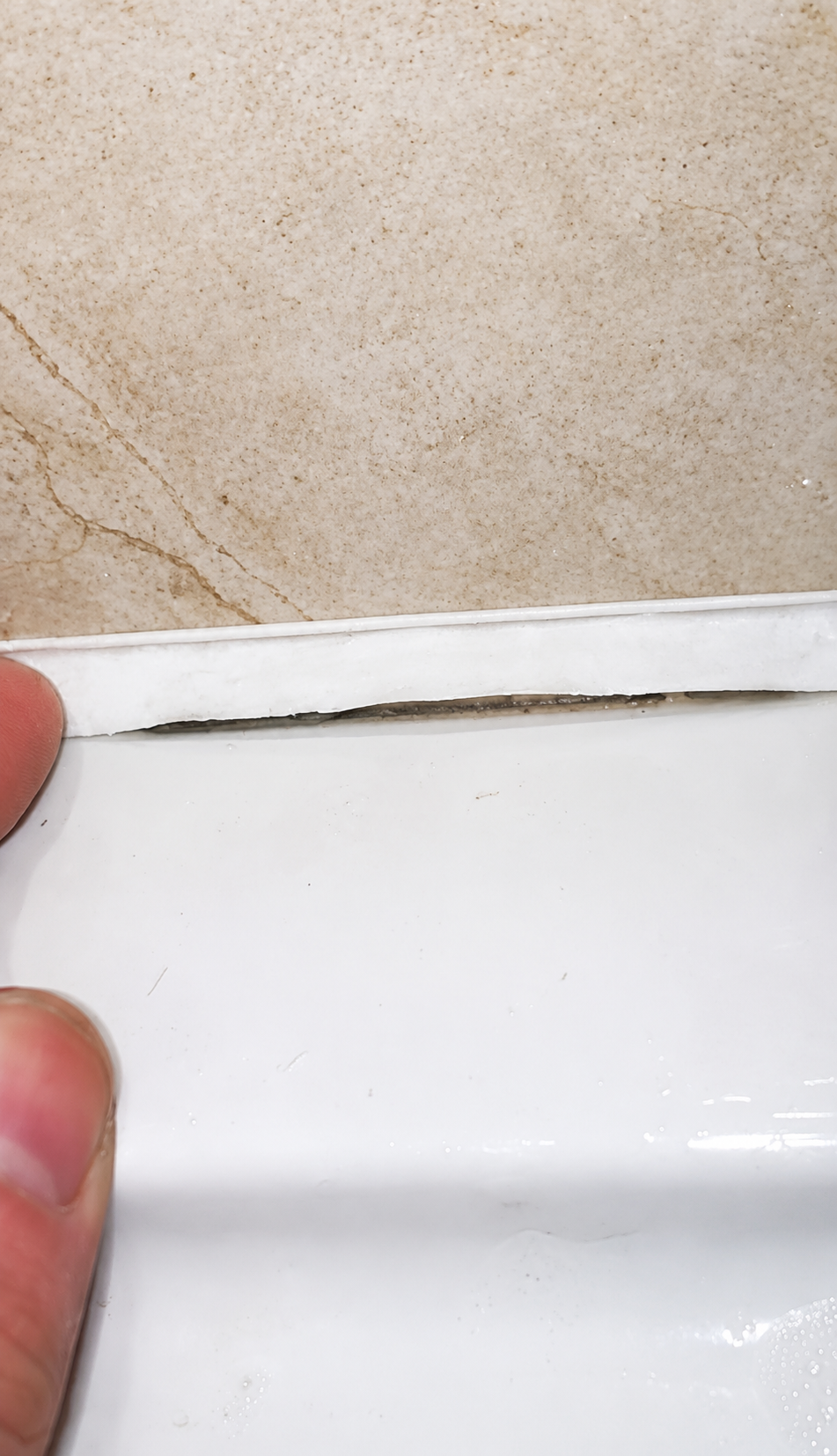 Failed shower tray silicone pulled away from the tray edge in Ongar