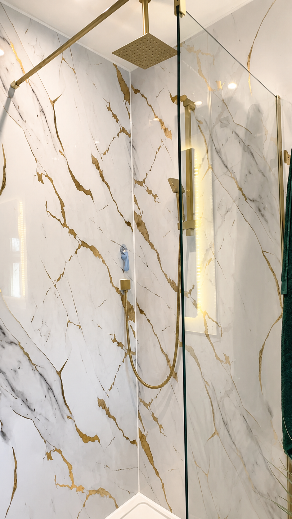 Ceiling-mounted brushed brass rainfall shower installed in a luxury bathroom renovation in Billericay