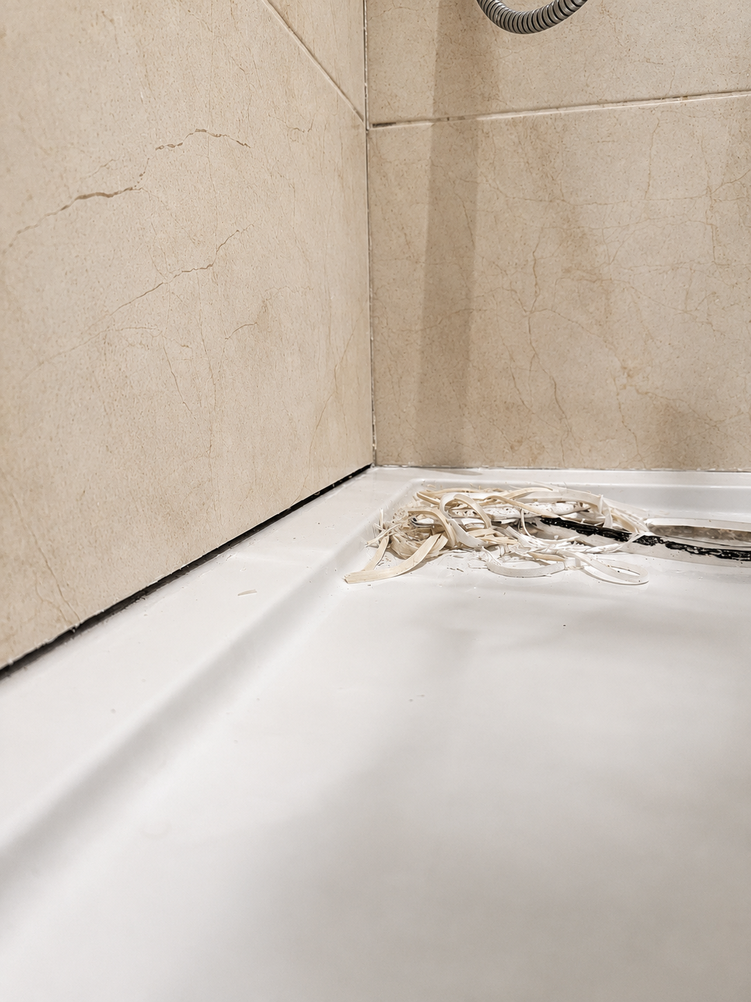 Old failed shower silicone stripped out ready for resealing in Ongar