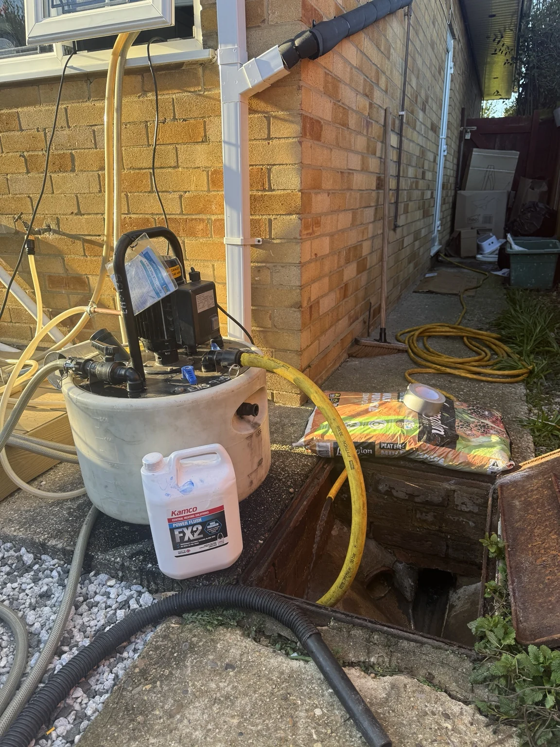 Kamco power-flushing machine with Kamco FX2 power flush cleaner, connected by hoses on an FFT job